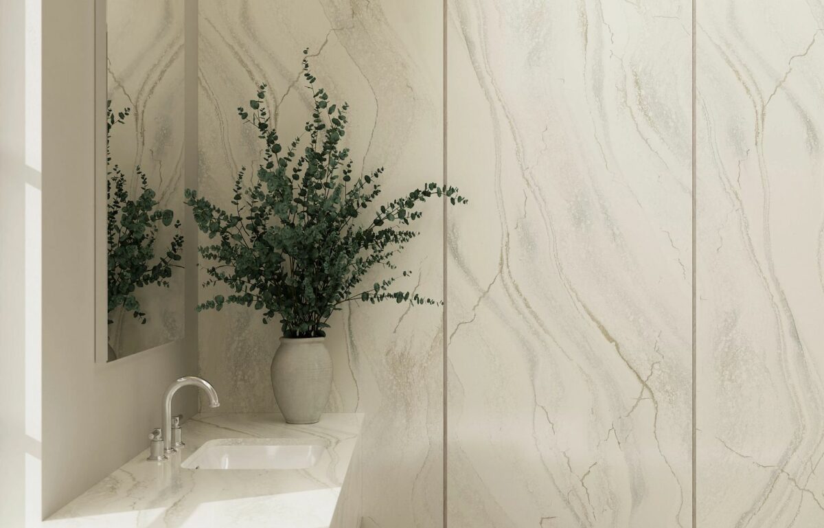 Close-up view of Cambria Inverness Everleigh Quartz surface, showcasing its intricate blend of cool gray and warm, sand-honey tones with debossed Inverness veins shower walls